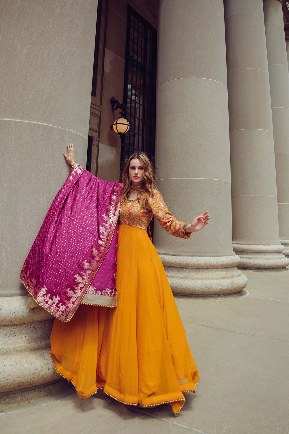 Yellow A-line georgette gown with hand-embroidered bodice, long sleeves, and magenta silk zari drape.