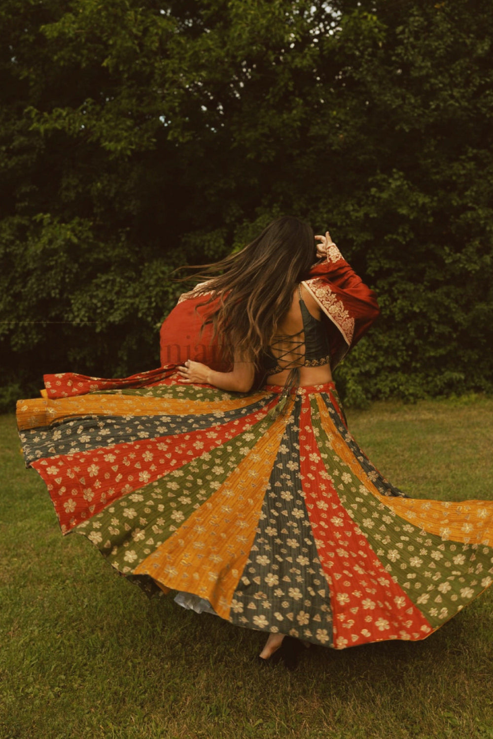 Zelie Silk Print Lehenga Choli: Woman twirling in multicolor floral silk chaniya choli with embroidered blouse.