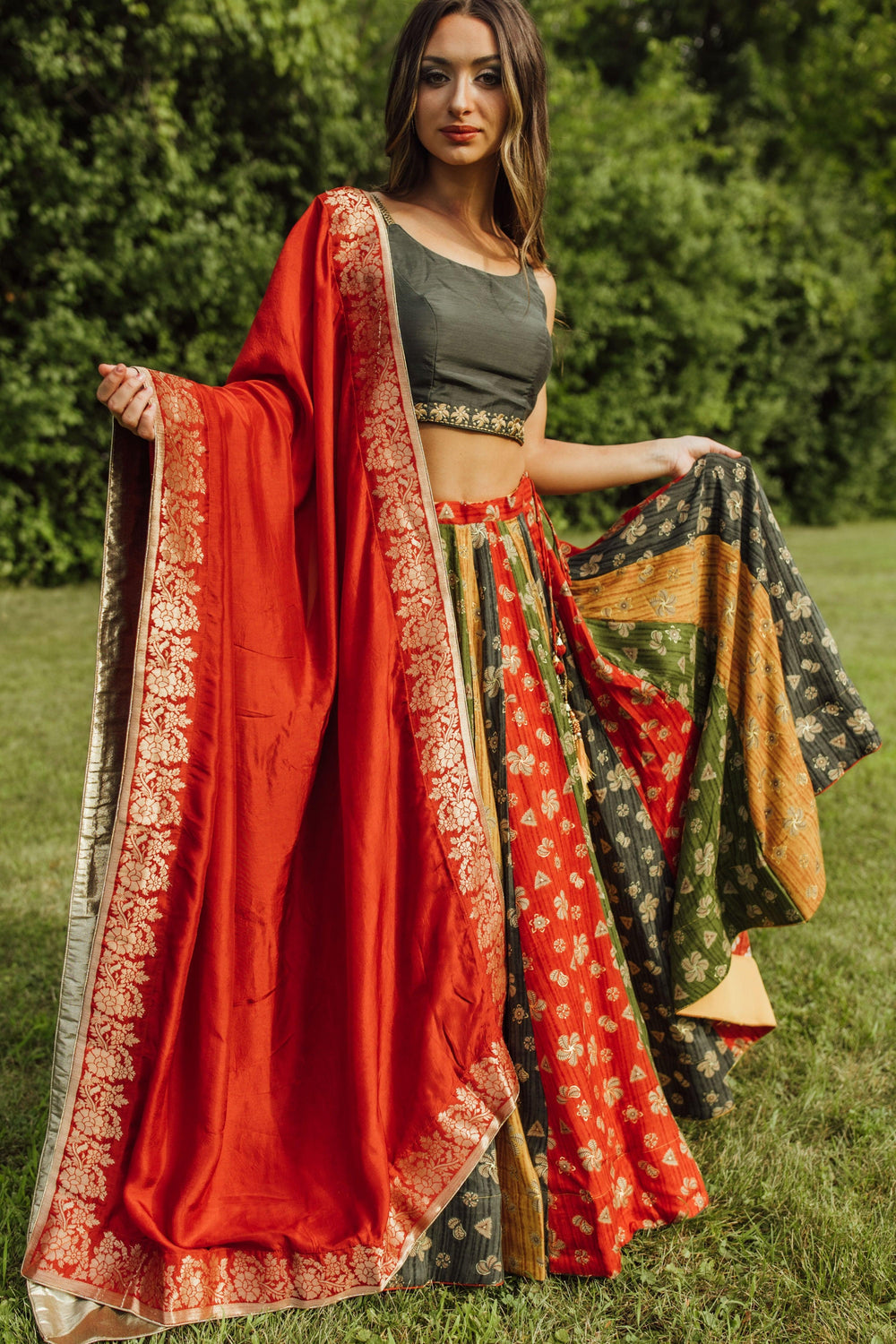 Zelie Silk Print Lehenga Choli: Woman in a dramatic twirl, wearing a multicolor silk chaniya choli with a red dupatta.