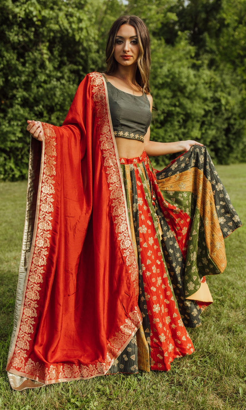 Zelie Silk Print Lehenga Choli: Woman in a dramatic twirl, wearing a multicolor silk chaniya choli with a red dupatta.
