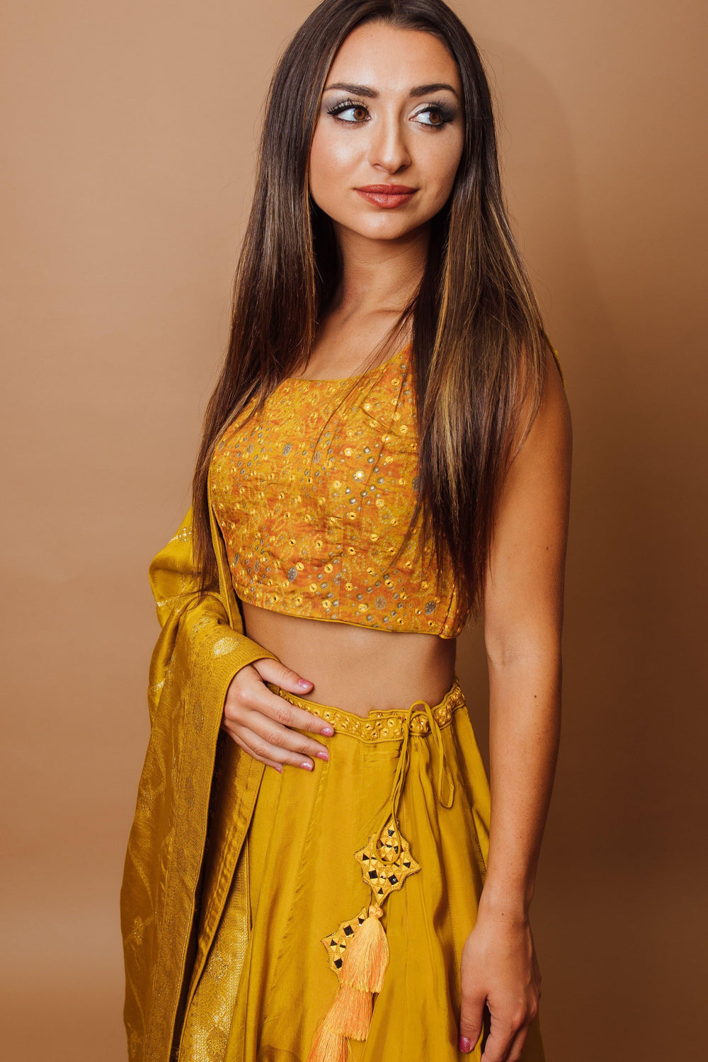 Closer front view of the embroidered blouse and tassel waist tie on the yellow haldi lehenga